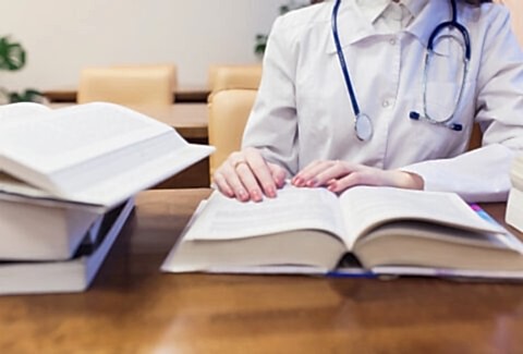 background a medical student for textbooks. The study of surgery by a beautiful girl in the library